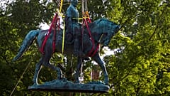 Workers remove the monument of Confederate General Robert E. Lee on Saturday, July 10, 2021 in Charlottesville, Va. 