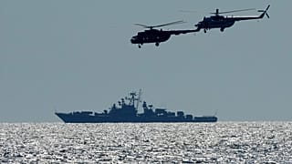 Hélicoptères ukrainiens avec un navire de guerre russe (en arrière-plan), durant les exercices militaires Ukraine-OTAN en mer Noire, le 09/07/2021