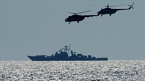 Hélicoptères ukrainiens avec un navire de guerre russe (en arrière-plan), durant les exercices militaires Ukraine-OTAN en mer Noire, le 09/07/2021