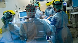 Medical staff tend to a COVID-19 patient in the intensive care ward of the Erasme hospital in Brussels, April 28, 2021.