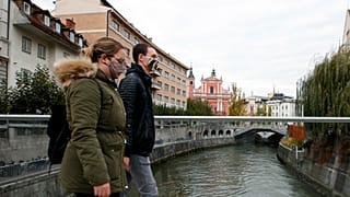 A couple cross the Ljubljanica river in downtown Ljubljana, Slovenia. 