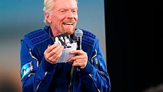 Richard Branson hält während der Pressekonferenz nach seinem Weltraumflug ein Foto seiner Eltern hoch