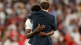 England's manager Gareth Southgate embraces Bukayo Saka after he failed to score a penalty during of the Euro 2020 final match at Wembley stadium in London,  July 11, 2021. 