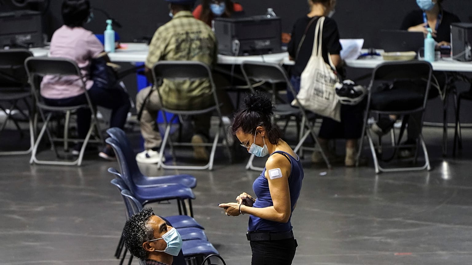 People wait after receiving the Pfizer-BioNTech COVID-19 vaccine, in a vaccination centre of Lyon.