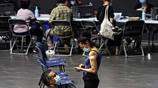 People wait after receiving the Pfizer-BioNTech COVID-19 vaccine, in a vaccination centre of Lyon.
