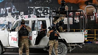 Police stand guard under an overpass in Port-au-Prince, Haiti, Monday, July 12, 2021.