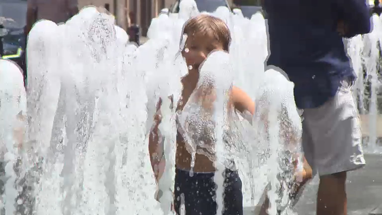 Ein Junge spielt in bis zum Anschlag aufgedrehten Wasserfontänen in Budapest