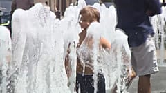 Ein Junge spielt in bis zum Anschlag aufgedrehten Wasserfontänen in Budapest