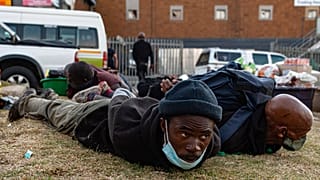 Suspect looters are held at the Bara taxi rank shops in Soweto, Johannesburg, Monday, July 12, 2021.