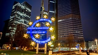A man walks past the Euro sculpture in Frankfurt, Germany, Thursday, March 11, 2021.