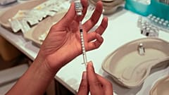 A medical staff prepares a syringe with the a Pfizer COVID-19 vaccine at a shopping mall in Paris.