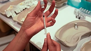 A medical staff prepares a syringe with the a Pfizer COVID-19 vaccine at a shopping mall in Paris.