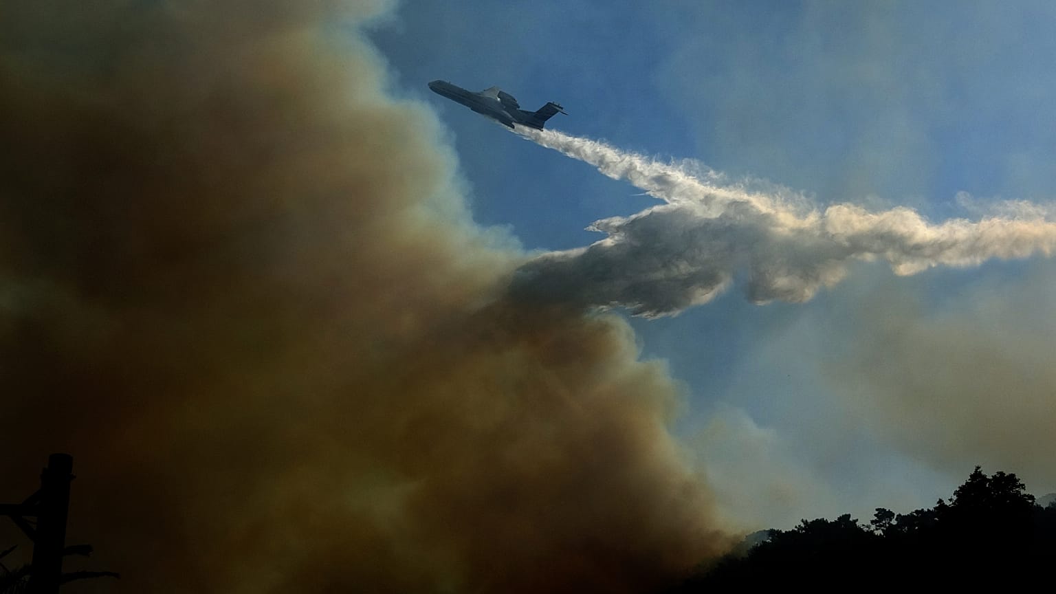 Ρίψη νερού από πυροσβεστικό αεροπλάνο στην προσπάθεια κατάσβεσης δασικής πυρκαγιάς που ξέσπασε σε δύσβατη περιοχή στους Βουρλιώτες Σάμου