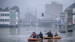 People use rubber rafts in floodwaters after the Meuse River broke its banks during heavy flooding in Liege, Belgium