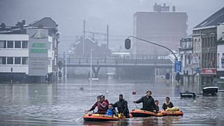 People use rubber rafts in floodwaters after the Meuse River broke its banks during heavy flooding in Liege, Belgium