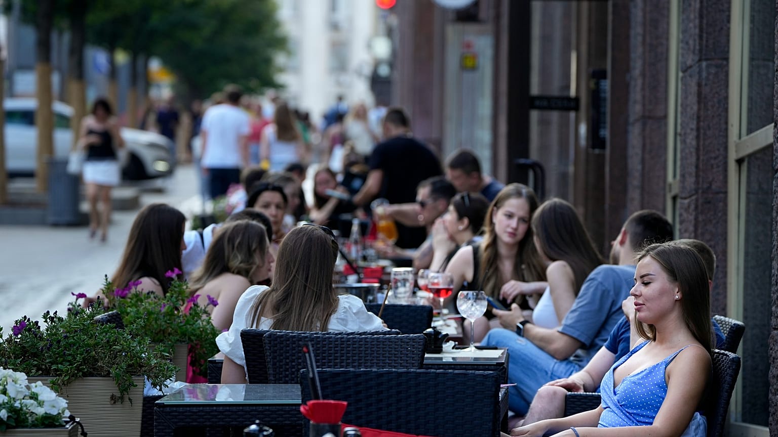 People relax after a hot day at an outdoor terrace of a restaurant in Moscow, Russia, July 14, 2021. 