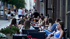 People relax after a hot day at an outdoor terrace of a restaurant in Moscow, Russia, July 14, 2021. 