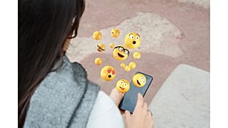 Woman using smartphone sending emojis