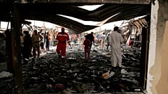 عمال الإنقاذ والمدنيون ينظفون موقع الحريق في جناح مستشفى فيروس كورونا حيث لقي عدة أشخاص مصرعهم في مستشفى الحسين التعليمي، في الناصرية