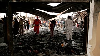 عمال الإنقاذ والمدنيون ينظفون موقع الحريق في جناح مستشفى فيروس كورونا حيث لقي عدة أشخاص مصرعهم في مستشفى الحسين التعليمي، في الناصرية