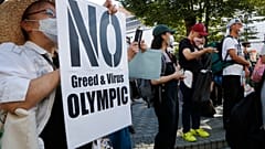 People gather for a rally in Tokyo's Shinjuku shopping district Sunday, July 18, 2021, to protest against the Olympics starting from July 23. 