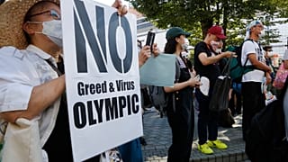 People gather for a rally in Tokyo's Shinjuku shopping district Sunday, July 18, 2021, to protest against the Olympics starting from July 23. 