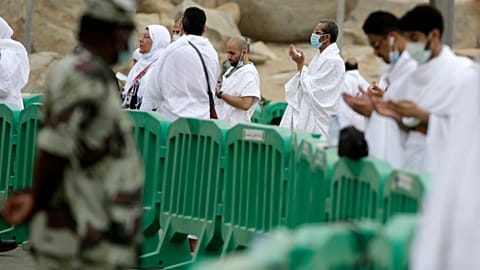 Pilgrims pray next to Mount Arafat
