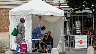 A medical technician administers nasal swabs at a mobile testing site in Versailles, west of Paris, Thursday, July 15, 2021.