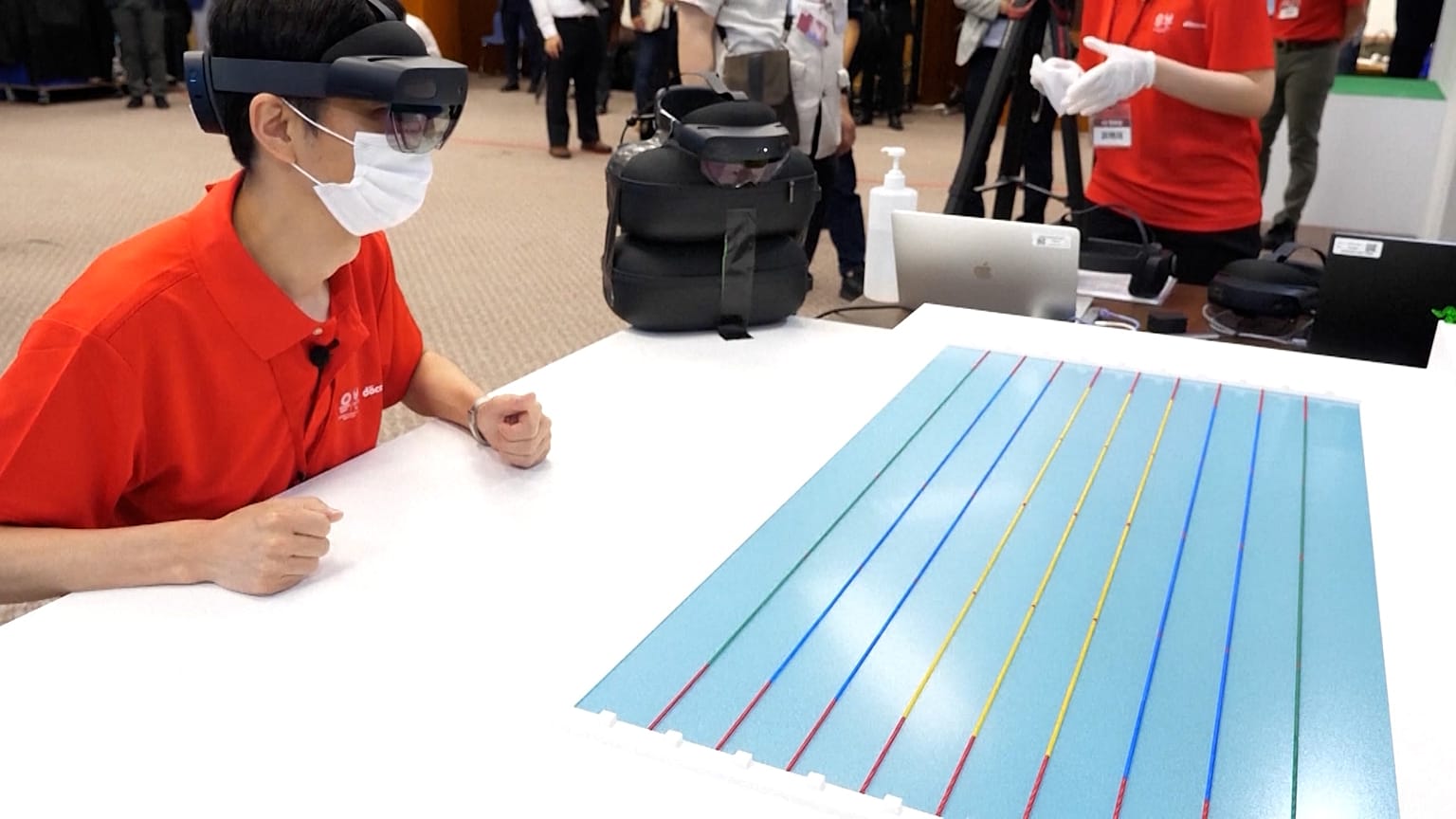 A fan uses an AR headset to observe an Olympic swimming event. 