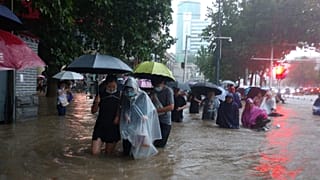 People move through flood water after a heavy downpour in Zhengzhou city, central China's Henan province on Tuesday, July 20, 2021. 