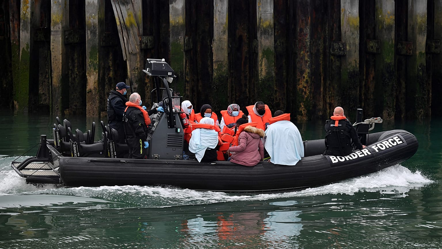 UK Border Force officials with migrants picked up in the English Channel, as they arrive in Dover, southeast England on August 15, 2020.