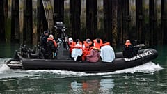UK Border Force officials with migrants picked up in the English Channel, as they arrive in Dover, southeast England on August 15, 2020.