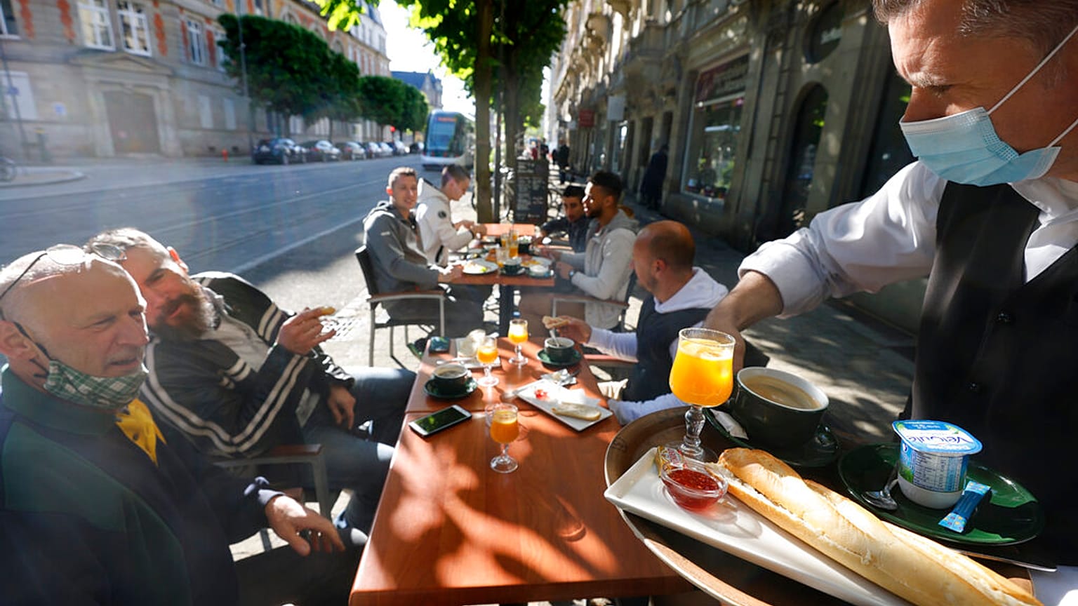 People enjoy a breakfast at a café terrace Wednesday, May, 19, 2021 in Strasbourg, eastern France.