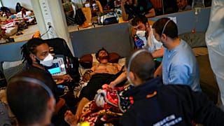 An ambulance is called for one of the migrants on hunger strike at the ULB Francophone university in Brussels on June 29, 2021