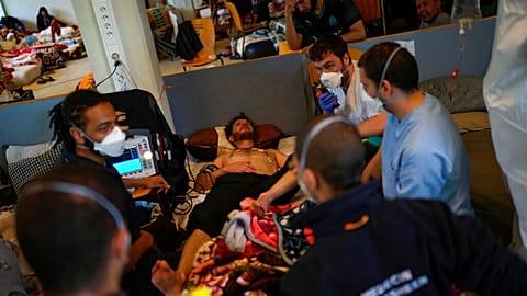 An ambulance is called for one of the migrants on hunger strike at the ULB Francophone university in Brussels on June 29, 2021