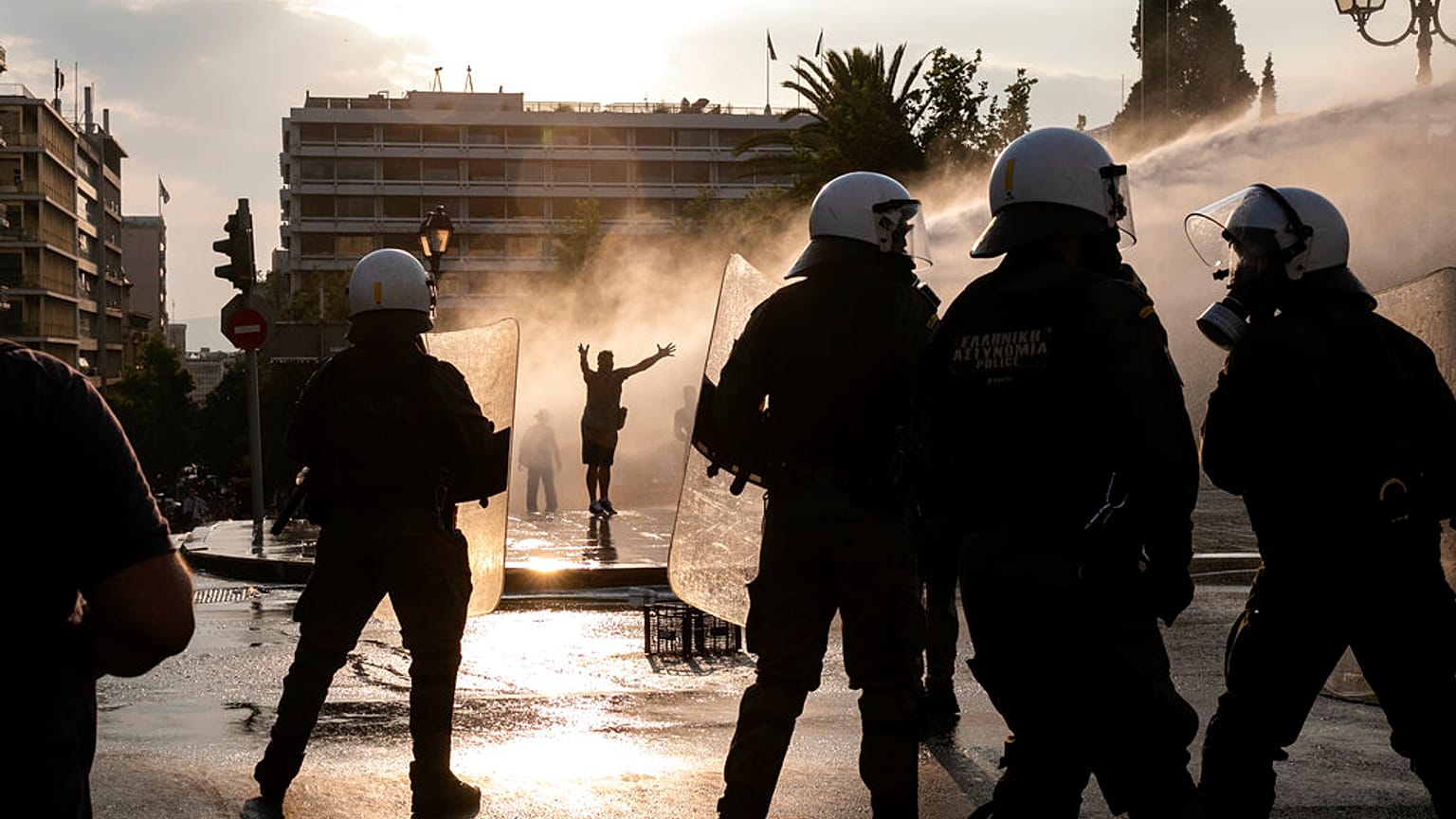 Greek police use tear gas and water cannons to disperse anti-vaccine protesters during a rally in central Athens on Wednesday