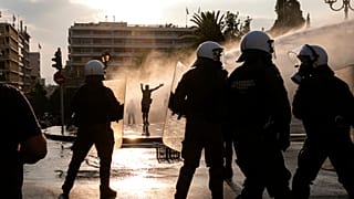 Greek police use tear gas and water cannons to disperse anti-vaccine protesters during a rally in central Athens on Wednesday