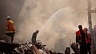 رجال إنقاذ وإطفاء فلسطينيين في وسط مدينة غزة بعد الانفجار.
