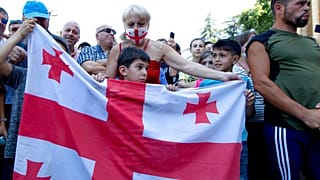 Opponents of the march wave a Georgian national flag as they block off the capital's main avenue to an LGBT march in Tbilisi, Georgia, Monday, July 5, 2021.