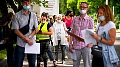 People wait in line to receive the COVID-19 jab at a Moscow vaccination centre in July