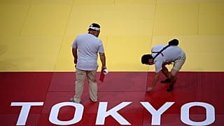 Judges, volunteers and technicians work inside the Nippon Budokan venue for judo and karate events in Tokyo 