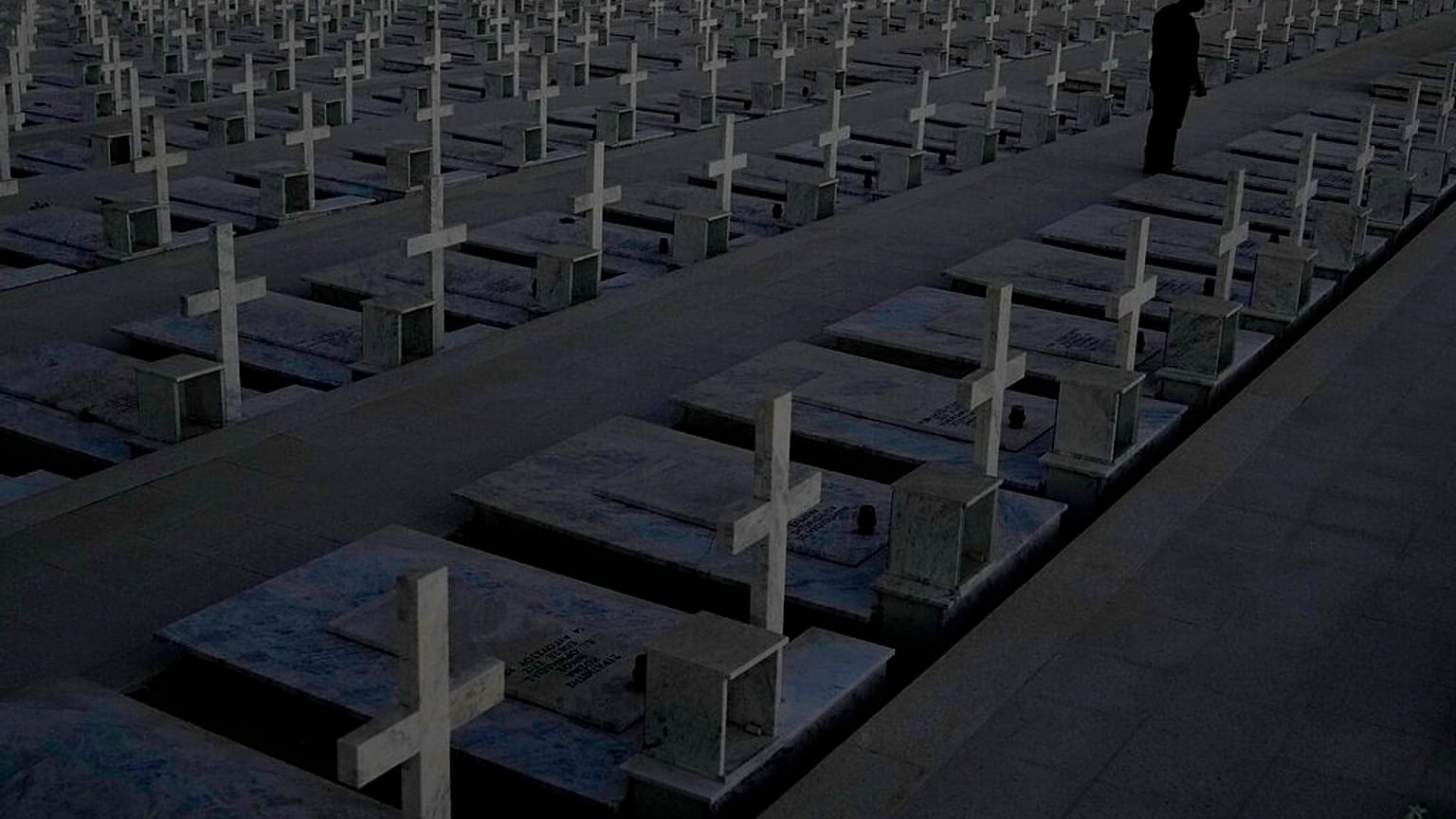 A man stands by the graves of soldiers killed in the 1974 Turkish invasion of Cyprus in the Tymvos Macedonitissas military cemetery 