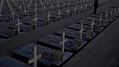 A man stands by the graves of soldiers killed in the 1974 Turkish invasion of Cyprus in the Tymvos Macedonitissas military cemetery 