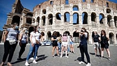 Tourists wear face masks to curb the spread of COVID-19 as they listen to a tour guide outside the ancient Colosseum, in Rome, May 21, 2021. 
