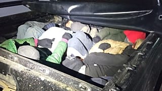 Migrants in the back of a vehicle stopped during the police operation