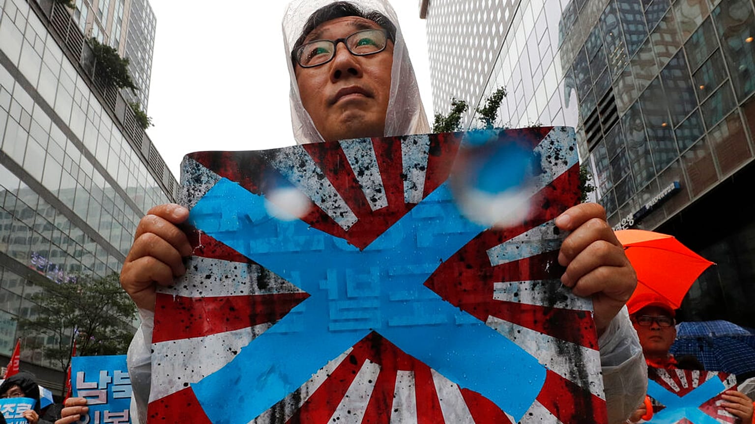 Güney Kore'nin başkenti Seul'de Japonya'nın imparatorluk dönemi kullandığı "doğan güneş" temalı bayrağı protesto eden bir vatandaş. 