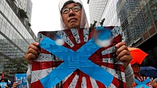 Güney Kore'nin başkenti Seul'de Japonya'nın imparatorluk dönemi kullandığı "doğan güneş" temalı bayrağı protesto eden bir vatandaş.