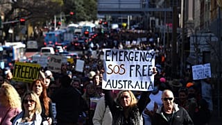 A koronavírus-járvány miatt elrendelt korlátozások ellen tüntetnek az ausztráliai Sydneyben 2021. július 24-én. A felirat szabadságot követel Ausztráliának.