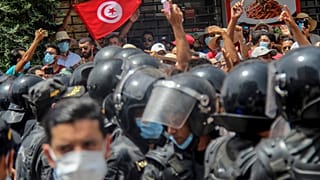 محتجون يقفون أمام عناصر الشرطة التونسية خلال مظاهرة في العاصمة تونس. 2021/07/25 