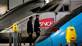 Train operator SNCF employees walk past a train at the Montparnasse train station, Paris. Dec.17, 2019.